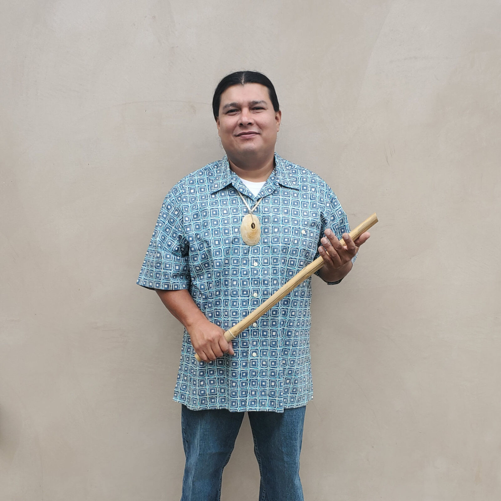 Lazaro stands against a beige background