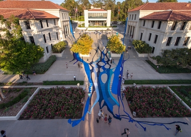A giant blue tapestry spread across the stairs in front of the AGC administrative building on Occidental College's campus