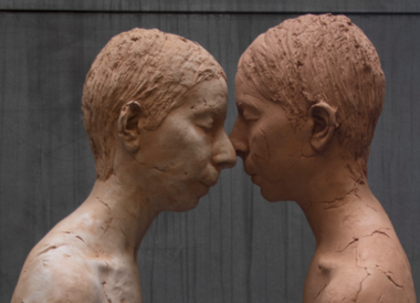 Two clay figures face-to-face.