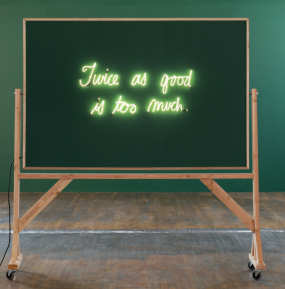 A blackboard that reads "Twice as good is too much" in neon letters