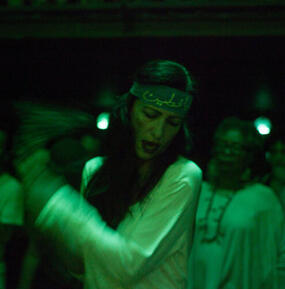 Artist dancing under green light. 