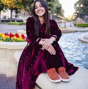 full color portrait of Aanii Tate sitting by a fountain