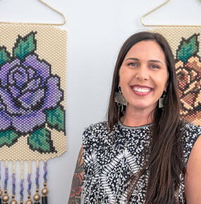 medium color portrait of Kimberly Robertson in front of beaded tapestries