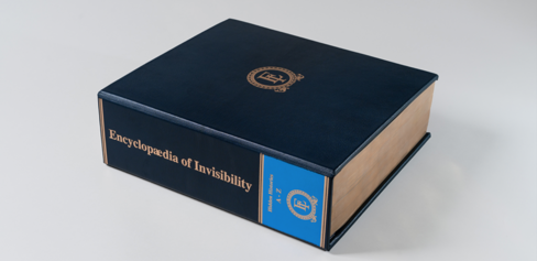 Photo of a blue leather bound book on a light grey background. 