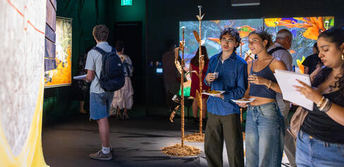Group of people observing Mario Lewis's "Forest Notebooks"