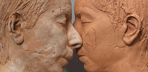 color photo of two sculptural faces by Roskana Pirouzmand, facing each other so their noses touch
