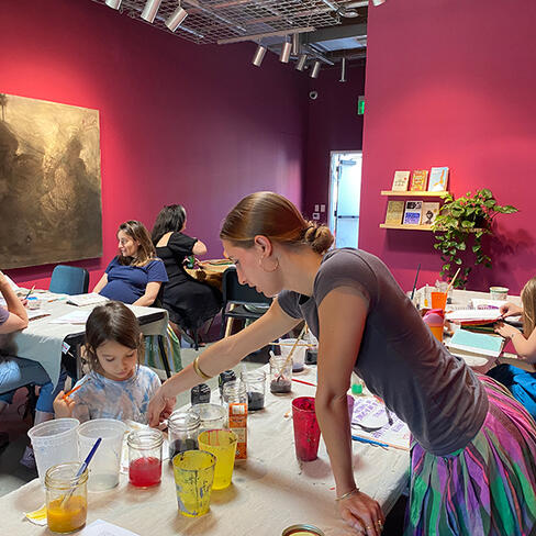 Teacher helping a student select natural ink.