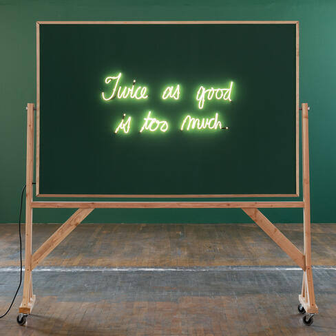 neon sign reads "twice as good is too much" on a chalkboard