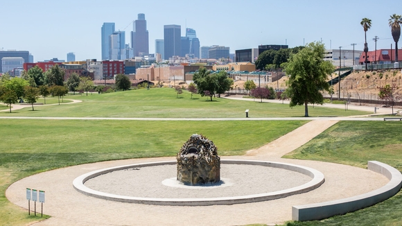 A beehive oven stands in LA Historic Park, with the city scape of downtown Los Angeles in the background