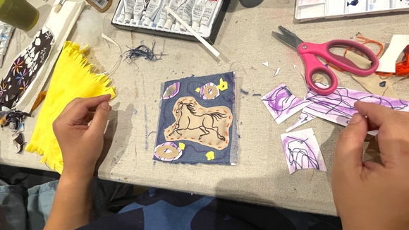 An artist making art with textiles and watercolor.