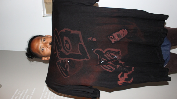 An artist holds up his bleach-dye t shirt.