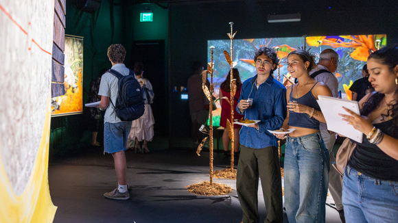 Group of people observing Mario Lewis's "Forest Notebooks"
