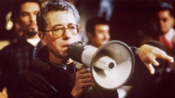 Jesús Salvador Treviño Directing Resurrection Blvd. Jesús wears glasses and stands with a megaphone, speaking to someone outside of the image frame. 