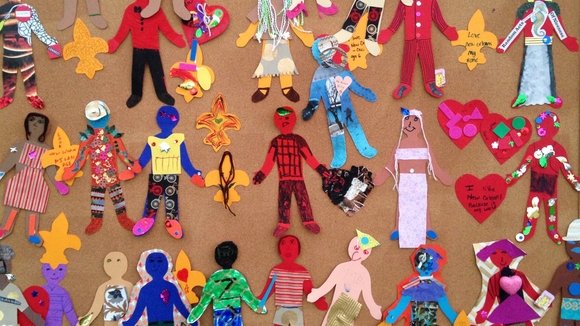 Colorful picture of children's artwork depicting different figures in brightly colored outfits. 