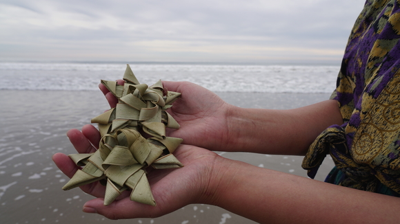 Photo of two hands holding star shaped sculptures made of natural fibers. 