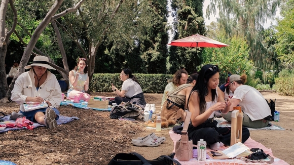 wide color photo of people doing crafts in a garden
