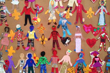 Colorful picture of children's artwork depicting different figures in brightly colored outfits. 