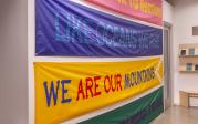 Four colorful banners that read "our power to nurture," "like oceans we rise," "we are our mountains," and "la maternidad sera deseada, o no sera"