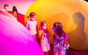 Three children playing between inflatables that are part of the F L O W ! exhibition