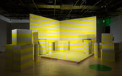 Stage with two walls painted with alternative yellow and white stripes and various painted objects