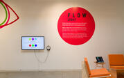 Red vinyl circle with exhibition text and monitor with headphones.