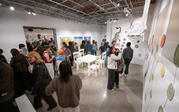 view of gallery with works from the studio art seniors, the room is full of visitors 