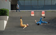 two performers in blue and yellow dancing on the Arthur G. Coons steps with orange beach chairs