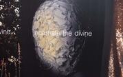 printed photo of mannequin with diamond face covering and words "incarnate the divine"