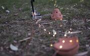 fairy lights on the ground on top orange clay dishes 