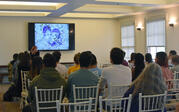 Shizu Saldamando presenting to audience alongside presentation depicting her artwork drawing of a couple
