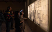 attendees examining a photo projection artpiece