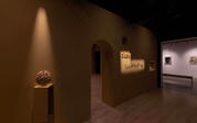 view of wall installation featuring a moon jar and ceramic lettering spelling out "DARK ILLUMINATION"