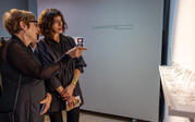 Curator Lael Lipschutz listening to artist Nina Humphrey as she points to her artwork "Searching Close."