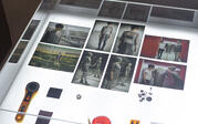 View of a glass case of photographs showing the process of making "Cosmic Bitcasting"