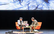 over audience wide shot of Kip Thorne and Paul Holdengraber on stage, with Lia Halloran painting projected behind