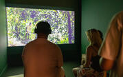 People with headphones on watching El Secreto del Rastro by Reyson Velásquez