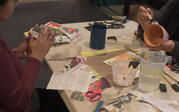 Artists pasting magazine clippings to terra cotta pots