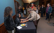 Robin Coste Lewis holds the hands of an excited woman during the book signing.
