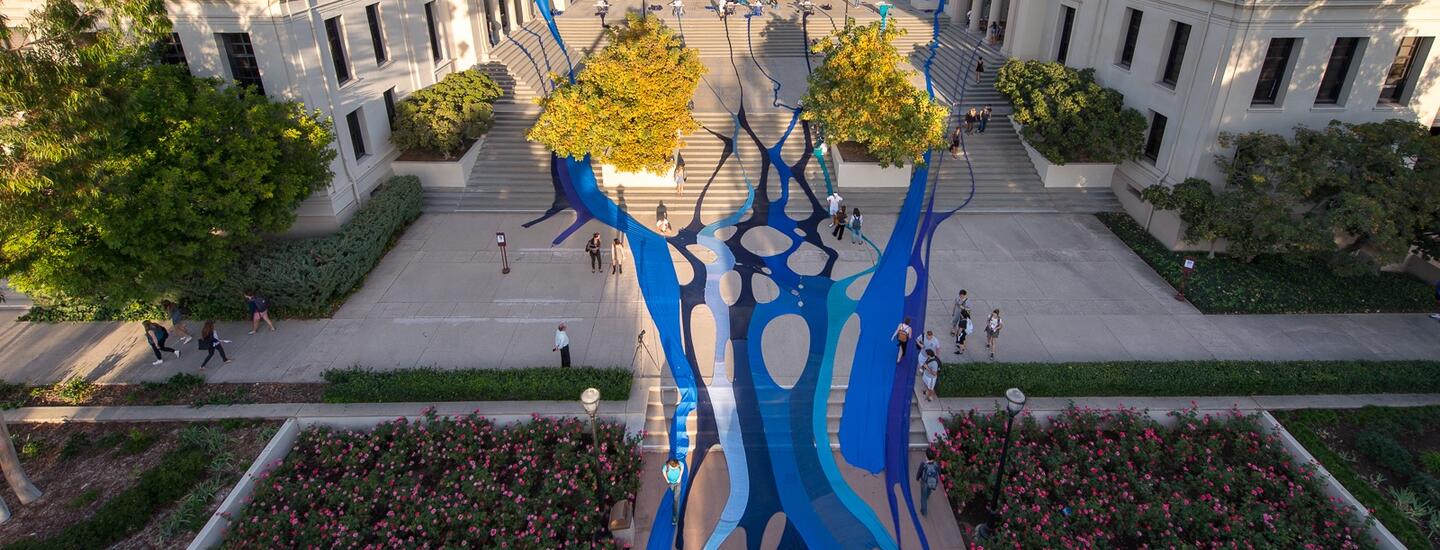 A giant blue tapestry spread across the stairs in front of the AGC administrative building on Occidental College's campus