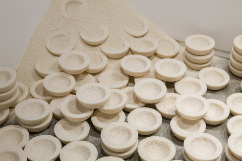 A pile of dozens of bowls made from white rice