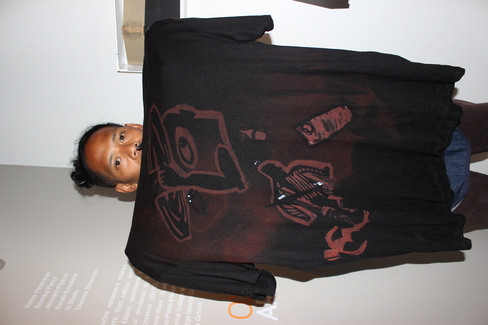 An artist holds up his bleach-dye t shirt.