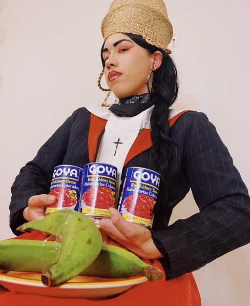 T Moreta holding Goya cans and plantains 