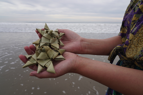Photo of two hands holding star shaped sculptures made of natural fibers. 
