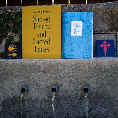 Colorful photo of two books sitting on a cement ledge.
