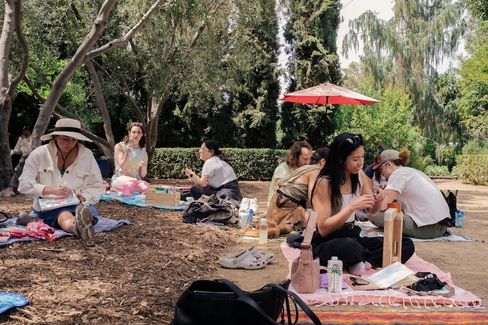 wide color photo of people doing crafts in a garden