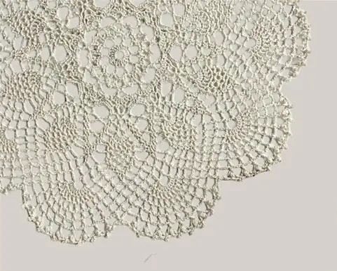 Close up of white lace doily on beige background 