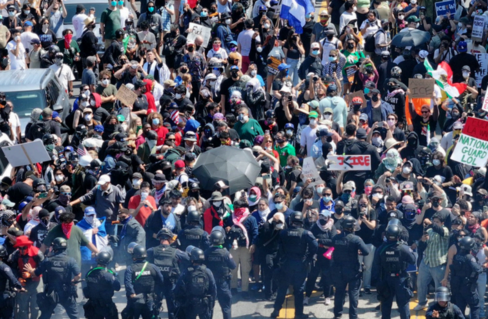 A gathering of people at a protest. The crowd is dense. 