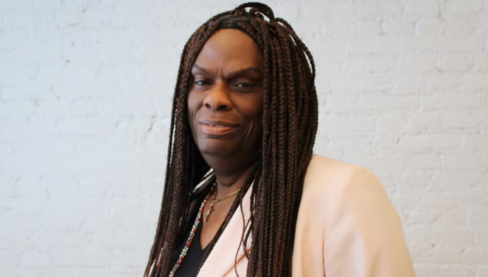 Portrait of Dee Farmer. She is wearing a cream colored shirt and looking into the camera smiling. 