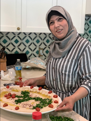 Miry presents a plate of food in a kitchen