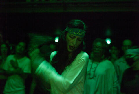 Artist dancing under green light.